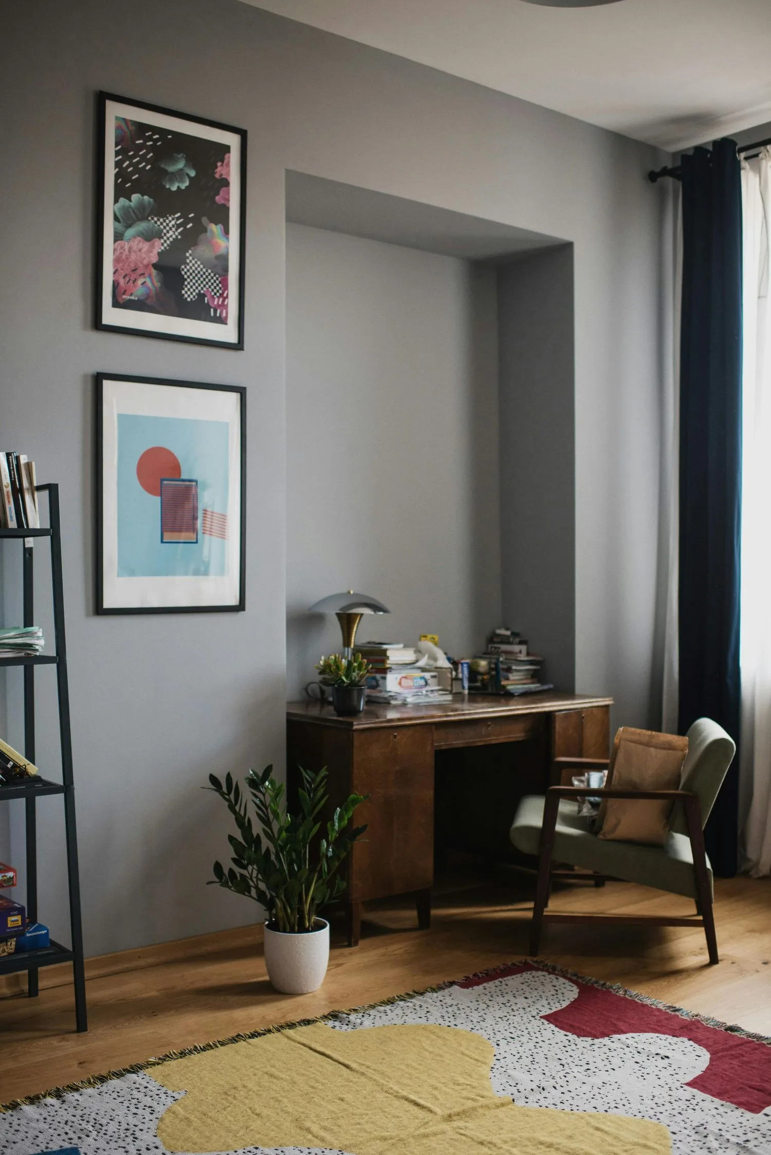 Coin bureau d’un salon : secrétaire en bois, affiches encadrées et fauteuil vintage