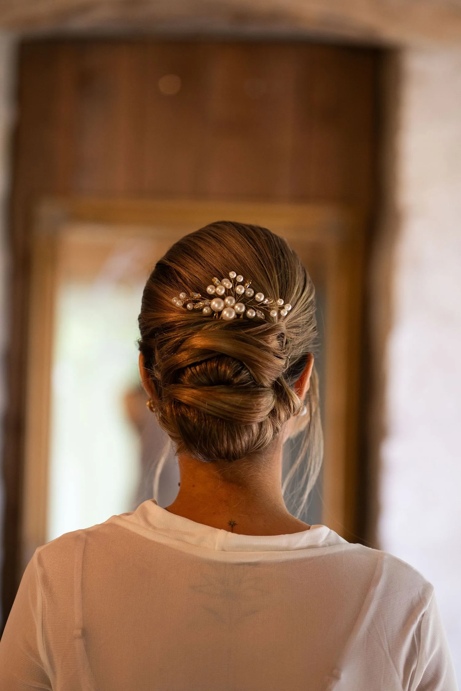 La mariée de dos, chignon orné d’un bijou de tête en perles