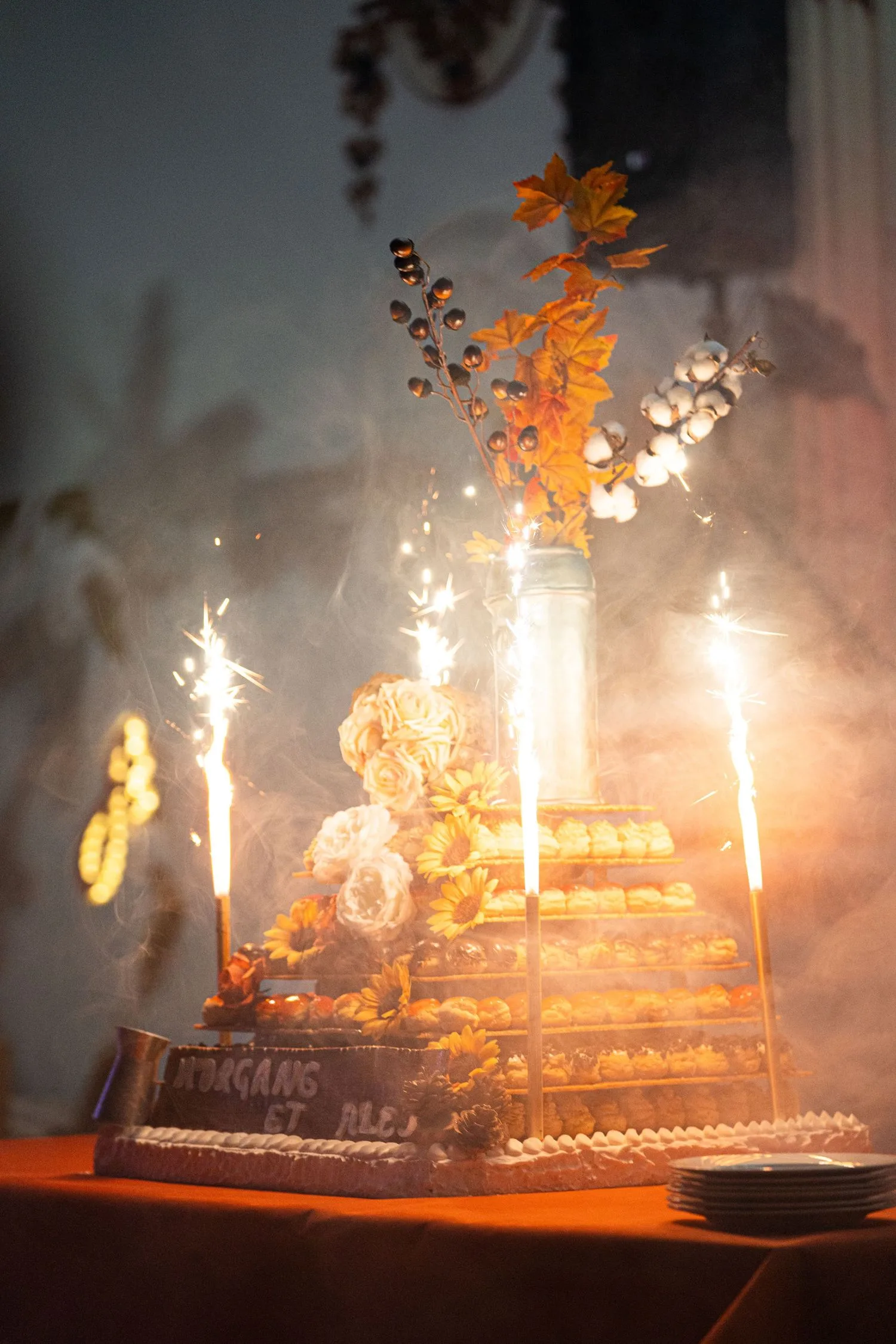 Pièce montée de choux illuminée par des fontaines à étincelles au moment du dessert