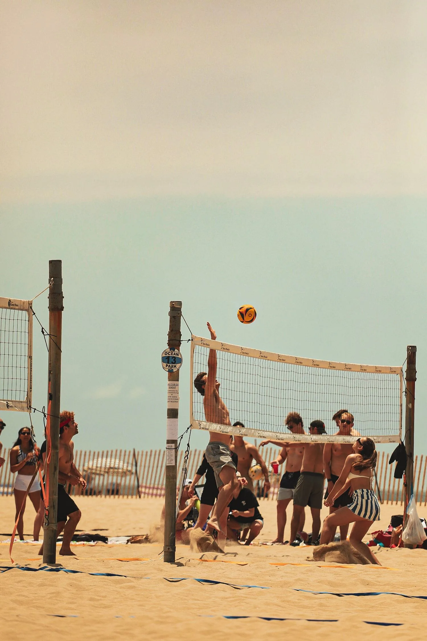 Joueur de beach-volley s’élève au filet pour smasher
