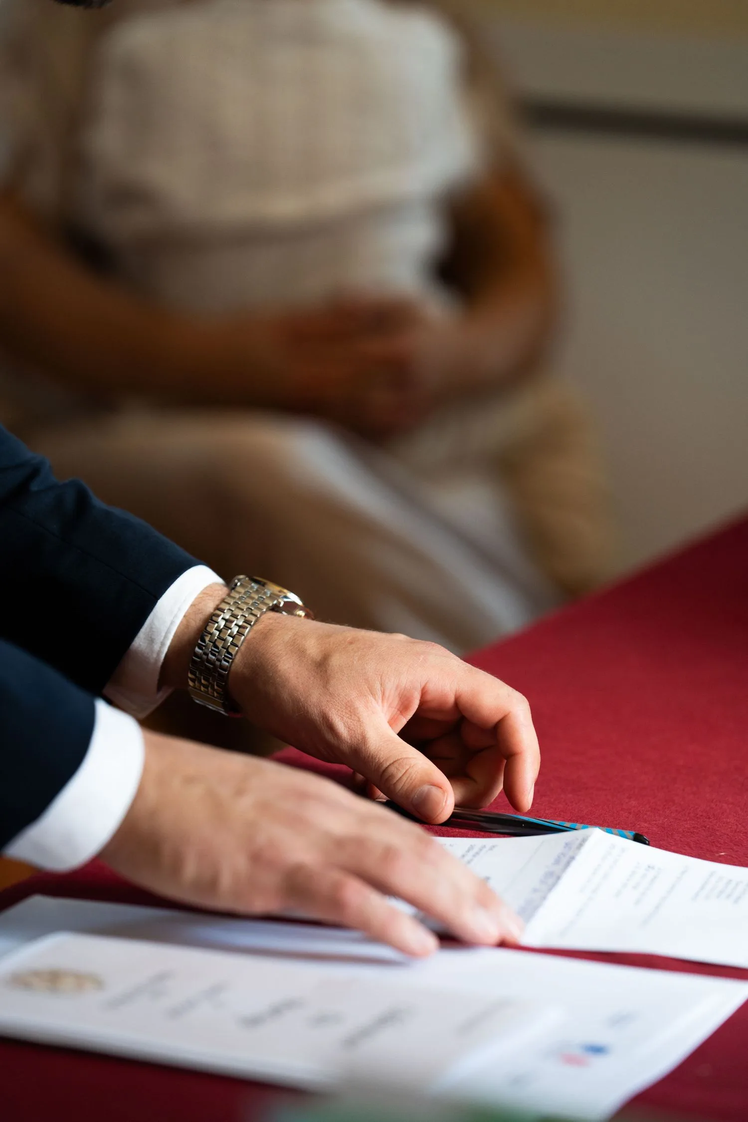 Signature des registres à la mairie, gros plan sur les mains du marié