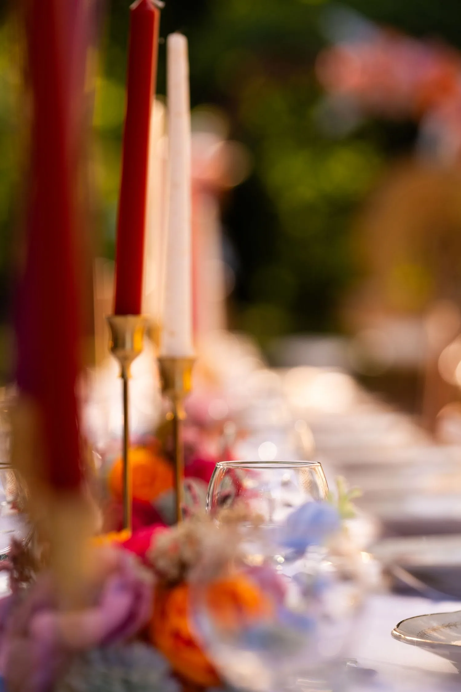Bougies rouges et crème dans des bougeoirs dorés sur la table de réception