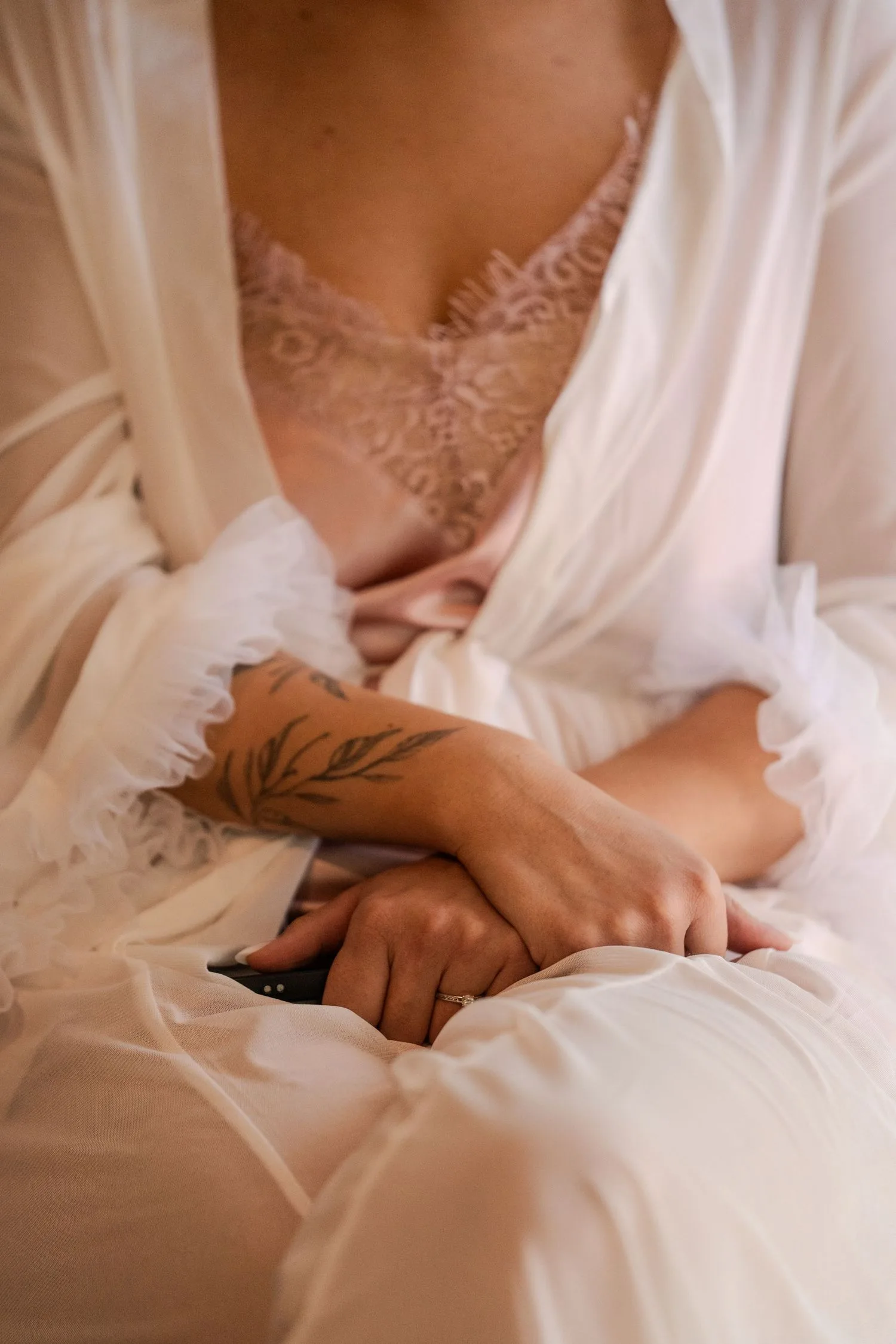 La mariée en peignoir de dentelle, bras croisés, avant l’habillage