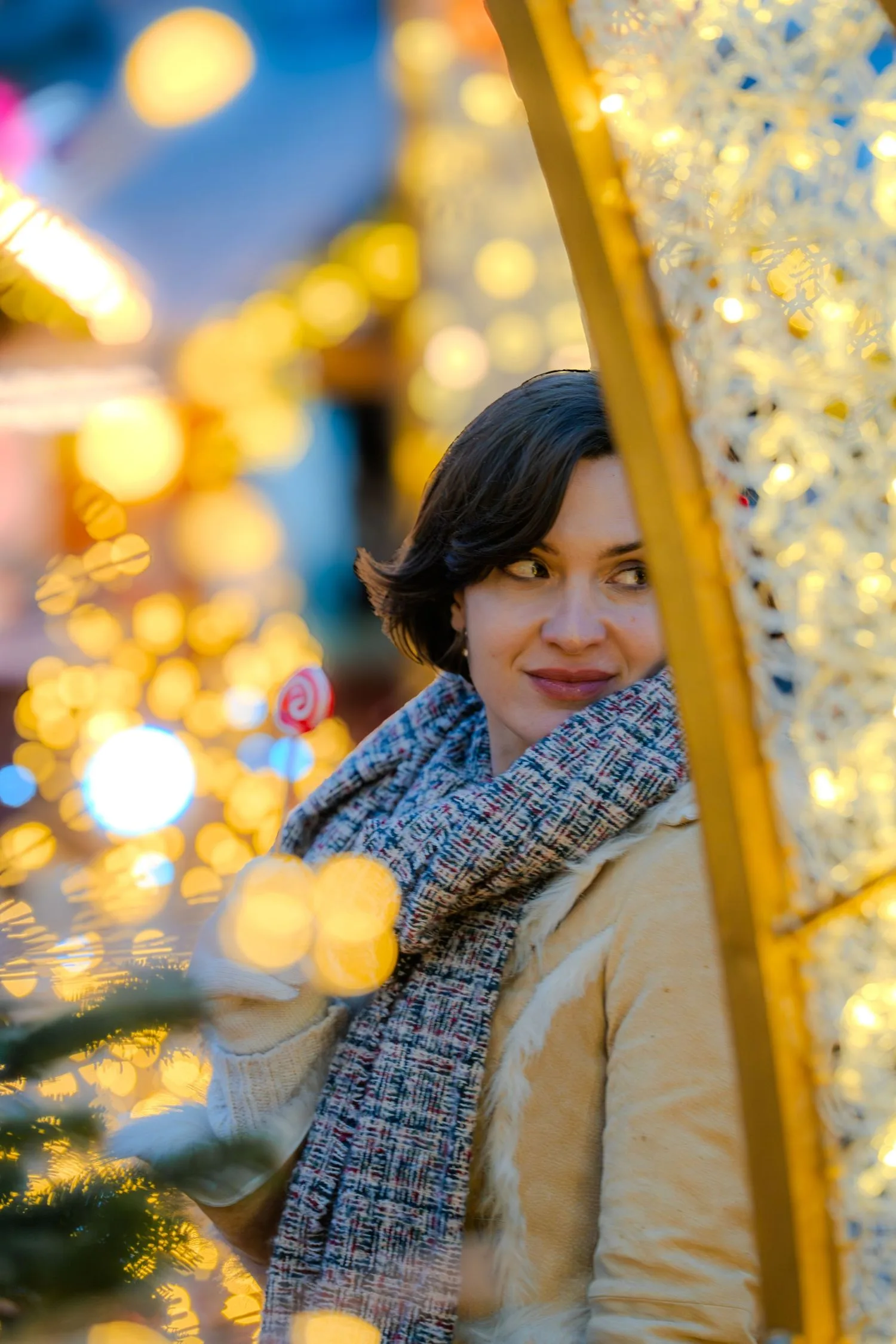 Portrait de soirée au marché de Noël, visage éclairé par les guirlandes dorées