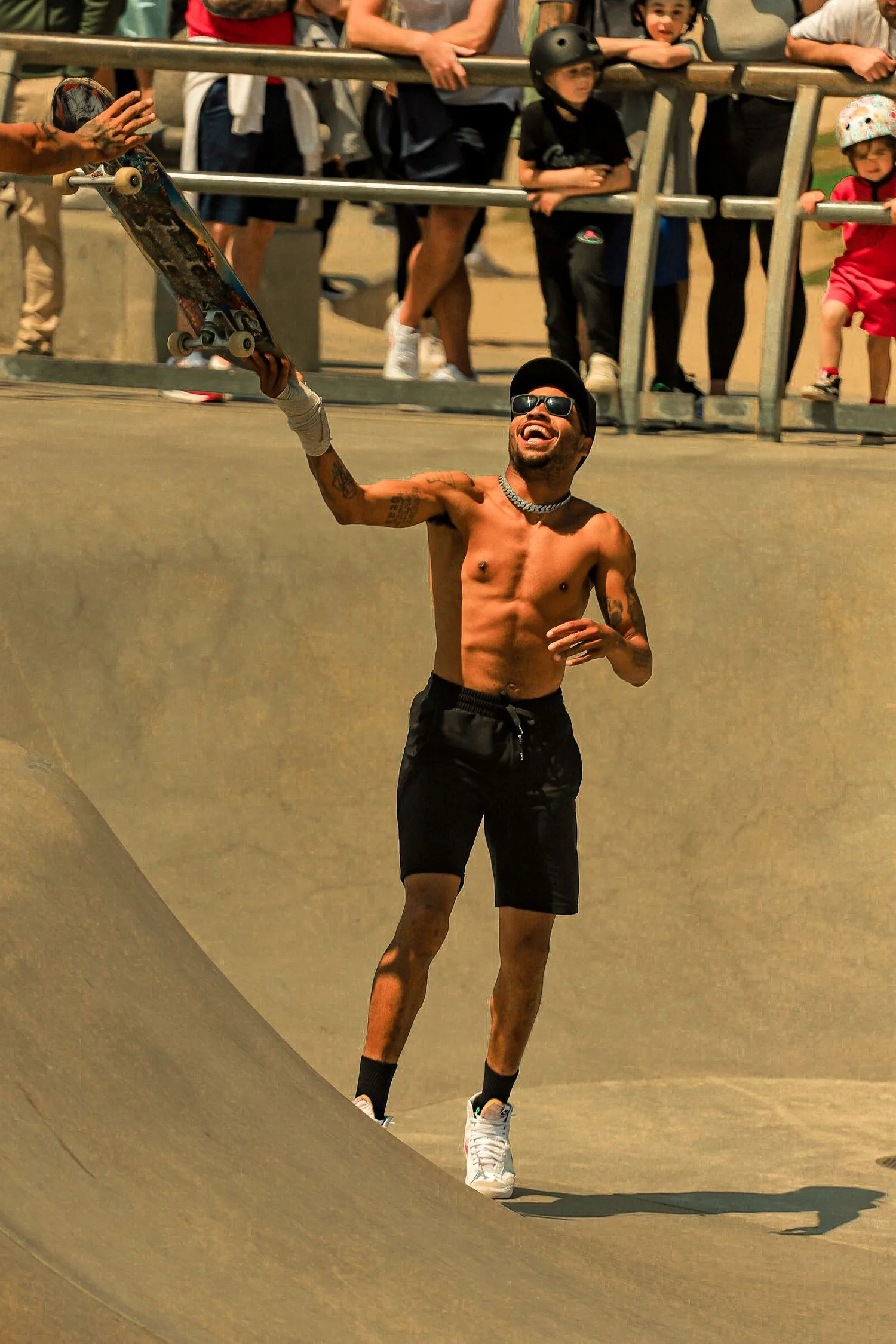 Un skateur brandit sa planche devant le public lors d’une compétition de skate